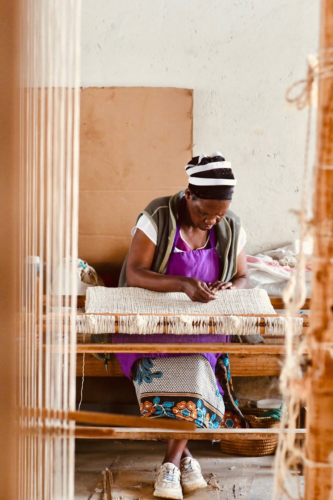 Artisan concentrating while weaving at a loom