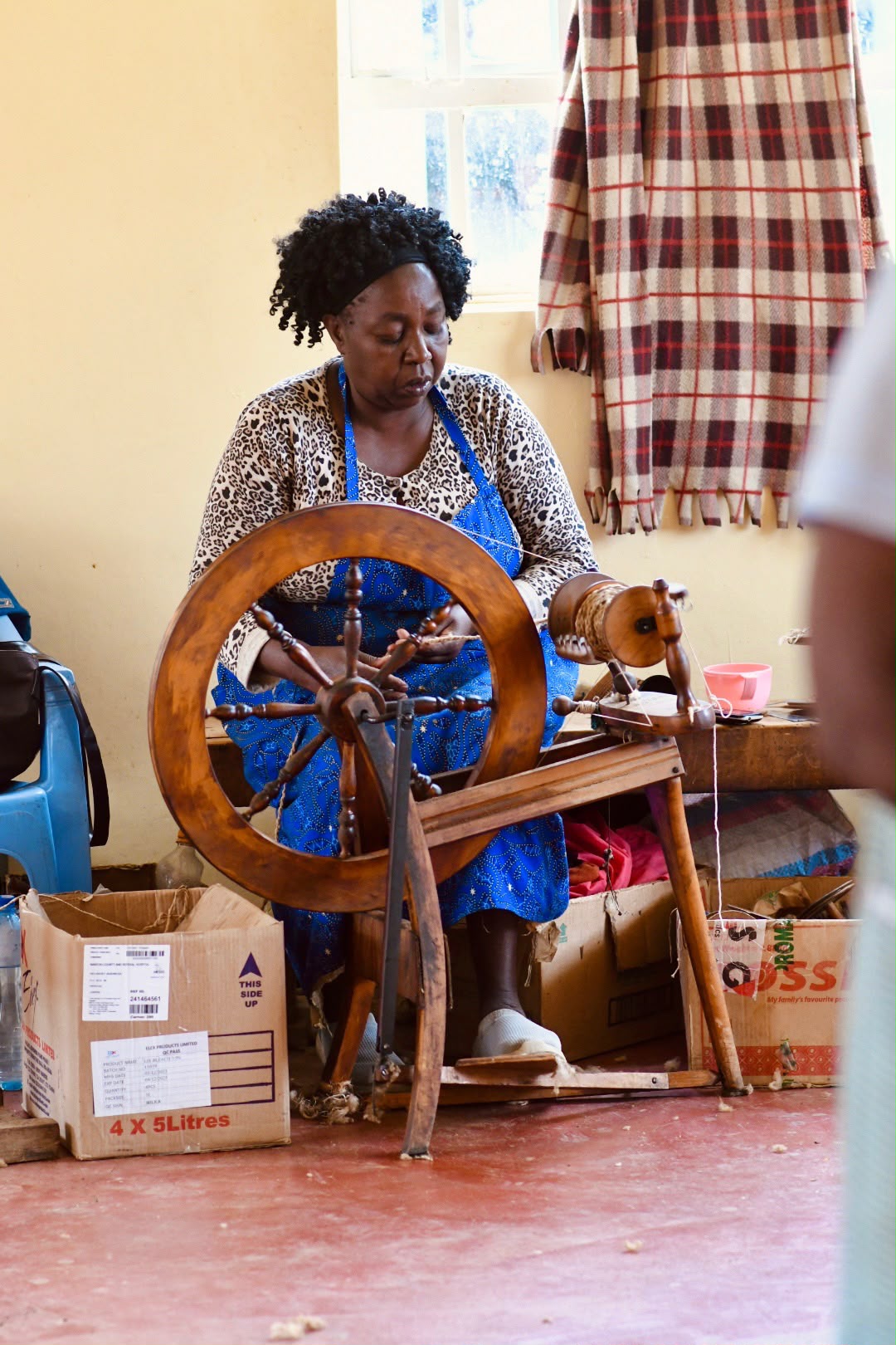 Artisan working at a wooden spinning wheel