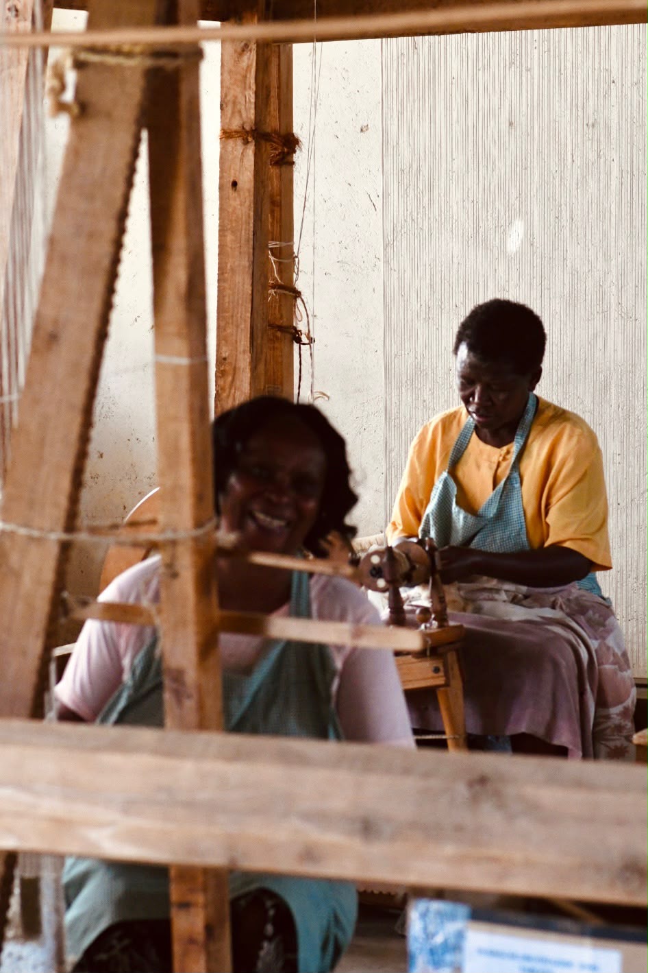 Two women working together at looms in the workshop