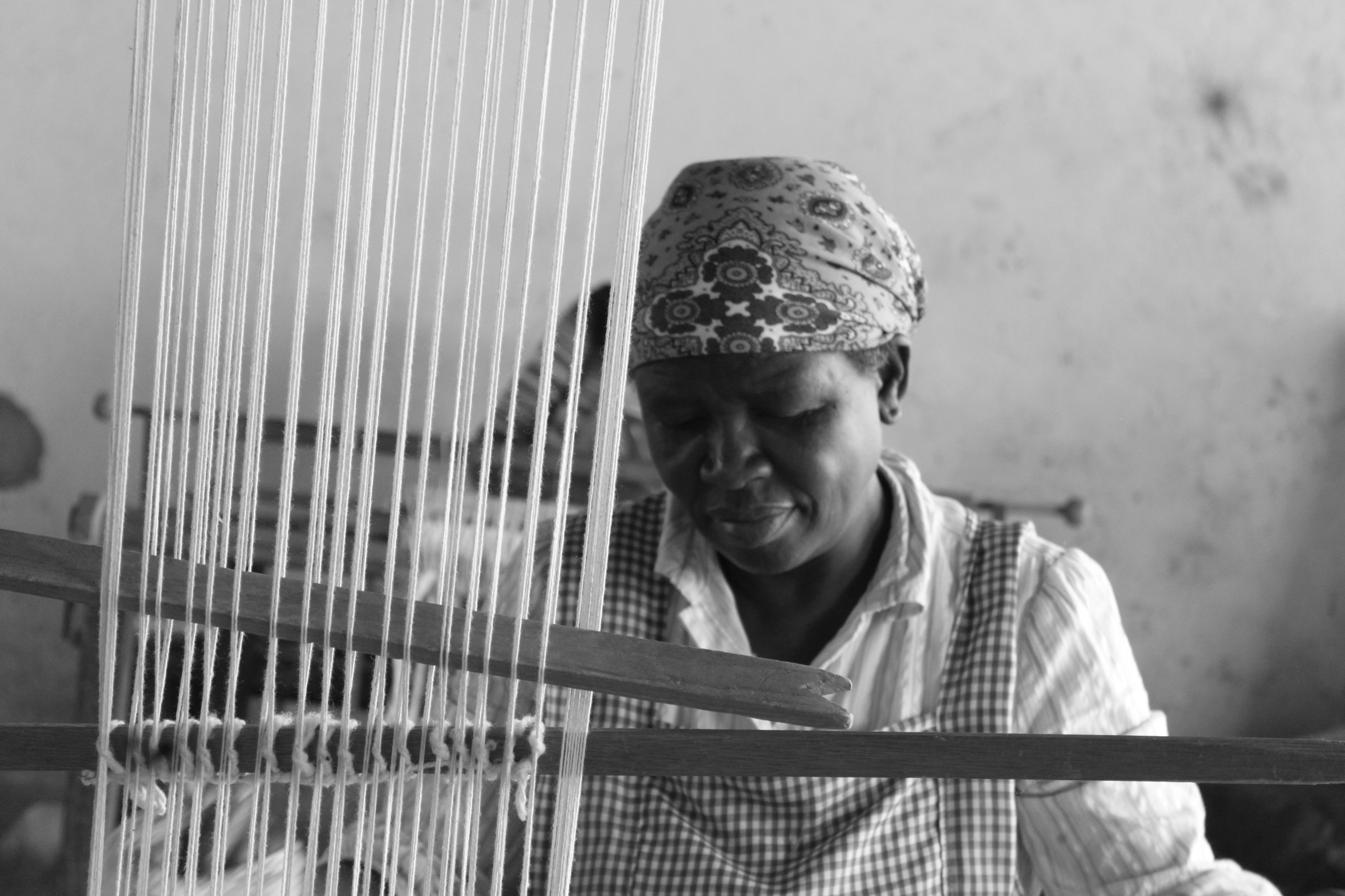 Close-up of hands weaving wool threads